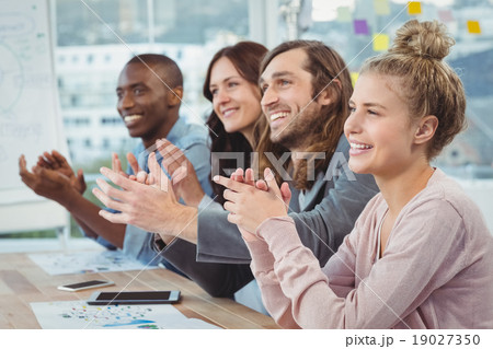 Happy business people clapping at desk 19027350