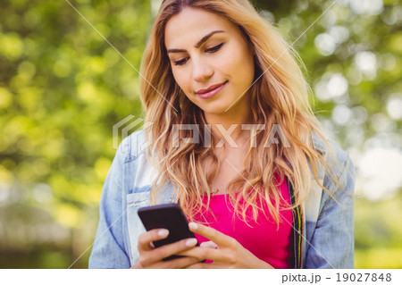 Smiling woman using mobile phone 19027848