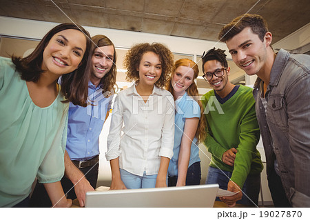 Portrait of smiling business people with laptop 19027870