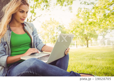 Beautiful woman using laptop at park Beautiful woman using laptop at park 19028705