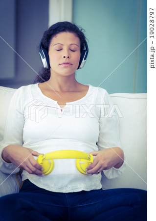 Woman sitting with eyes closed listening music 19028797
