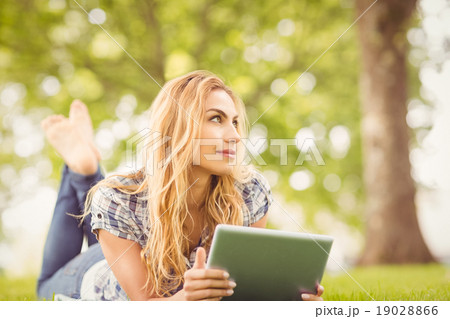 Smiling woman holding digital tablet at park Smiling woman holding digital tablet at park 19028866