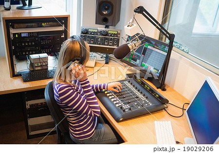 Female radio host operating sound mixer Female radio host operating sound mixer 19029206