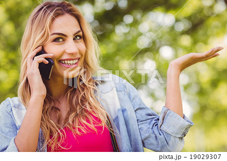 Portrait of smiling woman gesturing while using smartphone Portrait of smiling woman gesturing while using smartphone 19029307