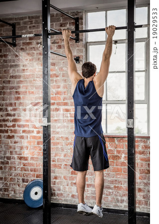 Rear view of man doing pull ups Rear view of man doing pull ups 19029533