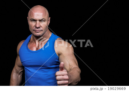 Portrait of confident muscular man showing thumbs up 19029669