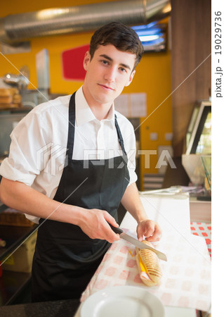 Portrait of male worker cutting sandwich Portrait of male worker cutting sandwich 19029736