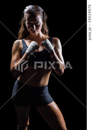 Portrait of female athlete with fighting stance Portrait of female athlete with fighting stance 19029976