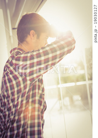 Low angle view of hipster looking through window Low angle view of hipster looking through window 19030127