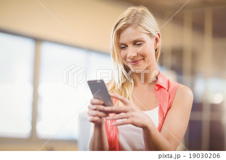 Beautiful businesswoman texting on phone 19030206