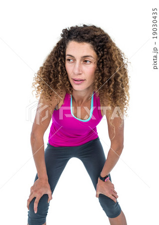 Tired young woman with hand on knees 19030435