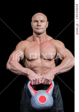 Portrait of muscular fit man lifting kettlebell 19030608