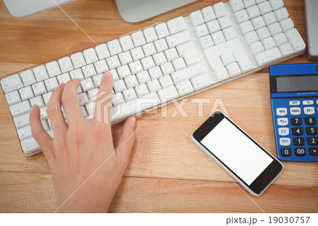 Man typing on keyboard at desk in office Man typing on keyboard at desk in office 19030757