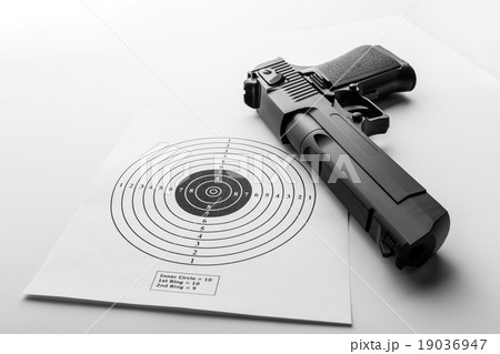 Paper target and pistol on white Paper target and pistol on white 19036947