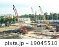 Crane operating among metal foundation poles 19045510