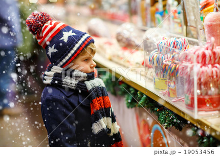 Little kid boy with candy cane stand on Christmas 19053456