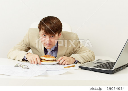 Young businessman is going to have dinner hamburger at office 19054034