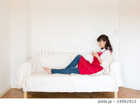 部屋でコーヒーカップを持って休憩する主婦 部屋でコーヒーカップを持って休憩する主婦 19062913