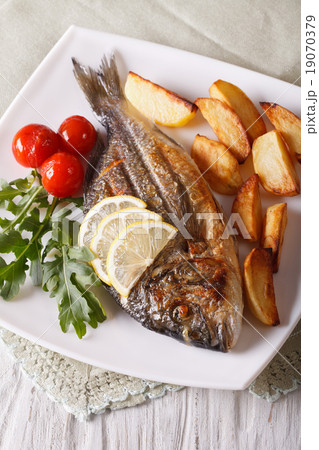 Grilled dorado fish with fried potatoes and tomato Grilled dorado fish with fried potatoes and tomato 19070379