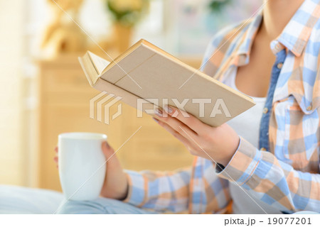 Girl is drinking tea and reading book. Girl is drinking tea and reading book. 19077201