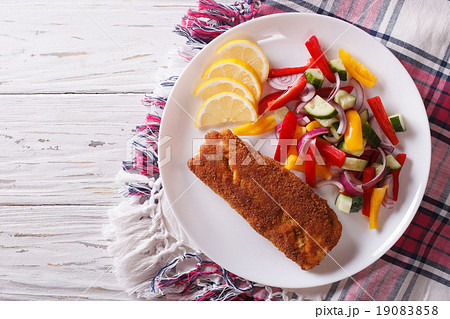 fried fish fillet with fresh vegetables and lemon 19083858