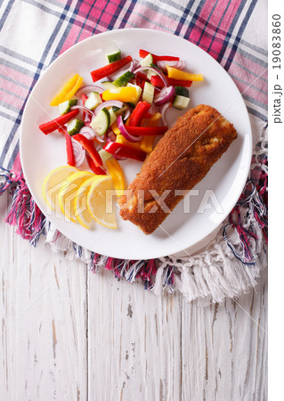 fried fish fillet with fresh vegetables and lemon 19083860