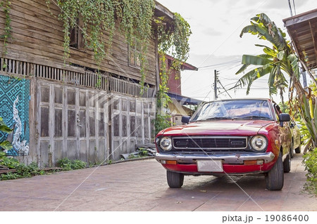 Vintage red Car with old wooden house 19086400