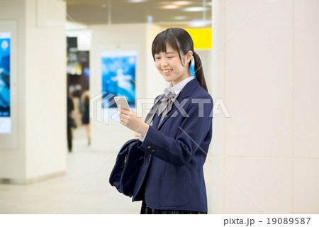 駅の地下通路に立っている制服姿の女子高生のポーズ 19089587