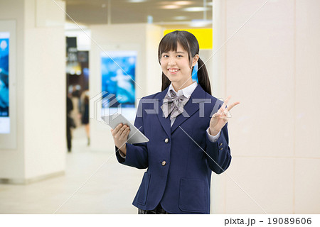 駅の地下通路に立っている制服姿の女子高生のポーズ 19089606