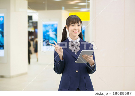 駅の地下通路に立っている制服姿の女子高生のポーズ 19089697