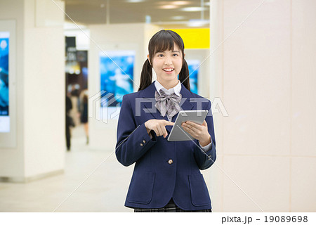 駅の地下通路に立っている制服姿の女子高生のポーズ 19089698
