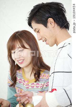 クリスマスツリーを飾るカップル 19104454