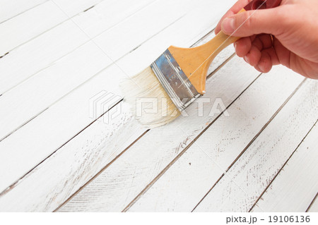 Hand holding brush and paint wooden surface Hand holding brush and paint wooden surface 19106136