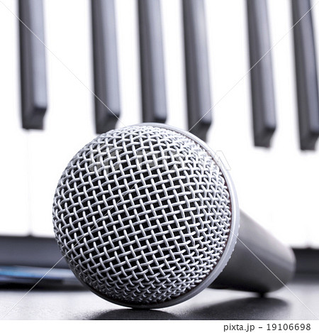 Microphone and piano keyboard on black table 19106698