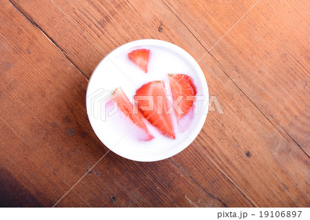 Slice of pie with strawberry on white plate, milk 19106897