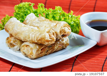 fried spring rolls on red bamboo mat 19107507