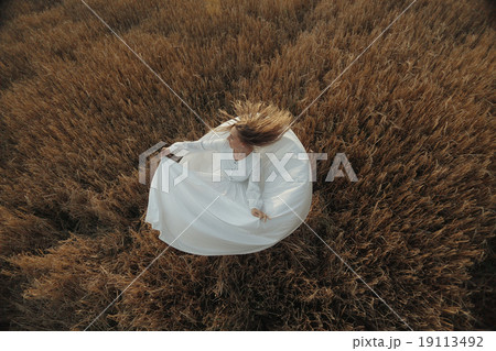 girl dancing in a field in white dress 19113492