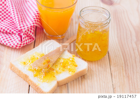 Breakfast with bread, jam and orange juice on wood table Breakfast with bread, jam and orange juice on wood table 19117457