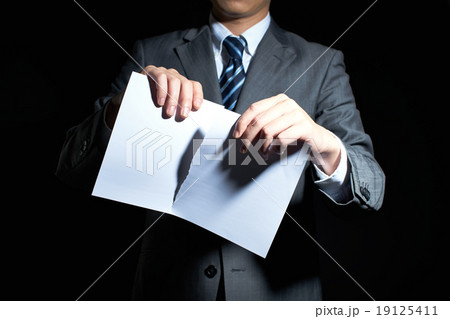 書類を破るビジネスマンの写真素材