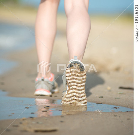 Sport footwear, sand footprints and legs close up. Runner feet d Sport footwear, sand footprints and legs close up. Runner feet d 19126301