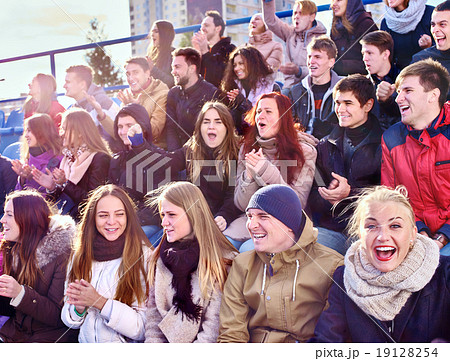Sport fans clapping and singing on tribunes. 19128254
