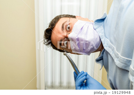 Dentist doing a dental treatment on a patient Dentist doing a dental treatment on a patient 19129948