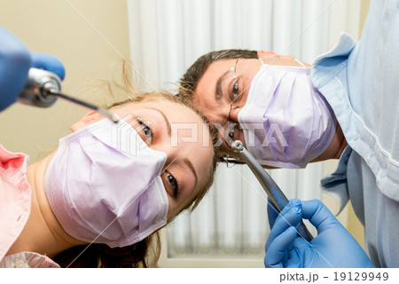 Dentist doing a dental treatment on a patient Dentist doing a dental treatment on a patient 19129949