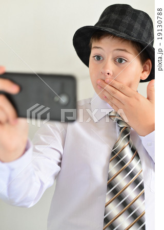 Teen boy with surprise looks at  mobile phone 19130788
