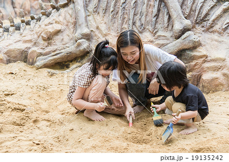 Asian family has fun digging in the sand 19135242