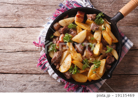 rustic fried potatoes with meat in a pan. top view rustic fried potatoes with meat in a pan. top view 19135469