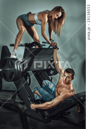 Sporty girl helps a man to do sports. Sporty girl helps a man to do sports. 19136053