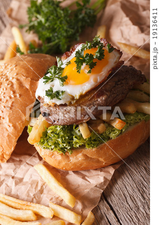 sandwich with beefsteak, fried egg and fries 19136411