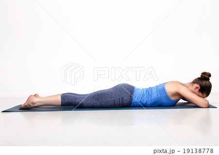 Sporty woman relaxes in yoga asana Makarasana 19138778