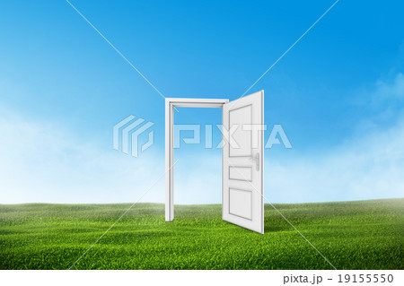 White door on a green grass field with blue sky 19155550